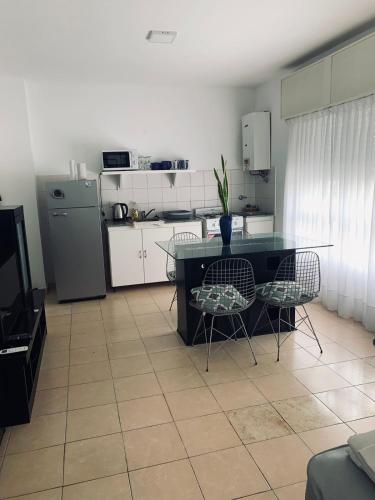 a kitchen with a table and chairs and a refrigerator at Sol - Departamento 6 in Concordia