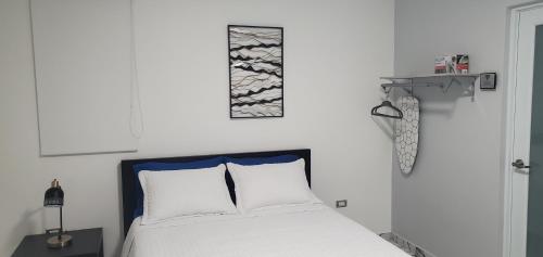 1 dormitorio con cama blanca y cabecero azul en 2 PALMAS STR, en Aguadilla