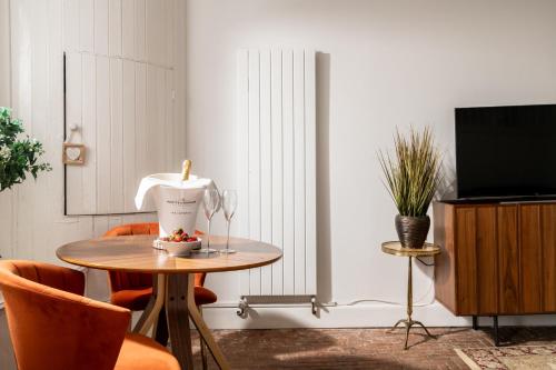 a room with a table and a television and a table and chairs at The Stable—Historic Property in Downwood Vineyard in Blandford Forum