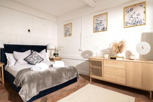 1 dormitorio con cama y tocador de madera en The Stable—Historic Property in Downwood Vineyard en Blandford Forum