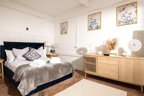 a bedroom with a bed and a wooden dresser at The Stable—Historic Property in Downwood Vineyard in Blandford Forum