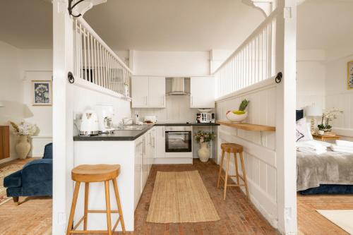 cocina y sala de estar con armarios blancos en The Stable—Historic Property in Downwood Vineyard, en Blandford Forum