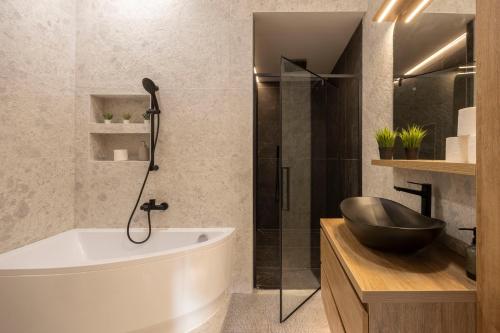a bathroom with a bath tub and a sink at Luxurious & Spacious Central Residence with Balcony in Budapest