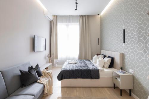 a small bedroom with a bed and a couch at Luxurious & Spacious Central Residence with Balcony in Budapest