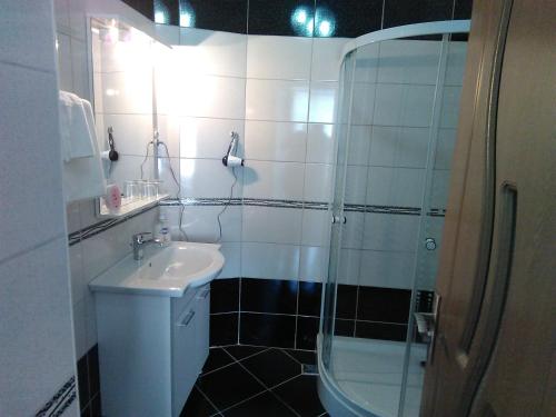 a white bathroom with a sink and a shower at Casa Anda in Sibiu