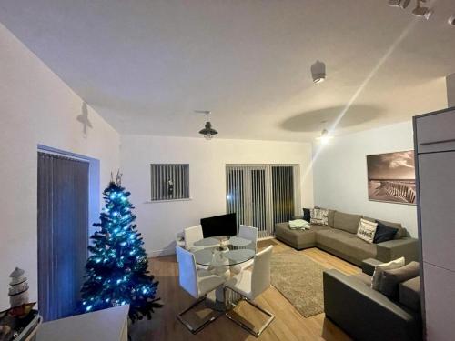 a living room with a christmas tree in it at Coastal apartment with beach on your doorstep! in Llanelli