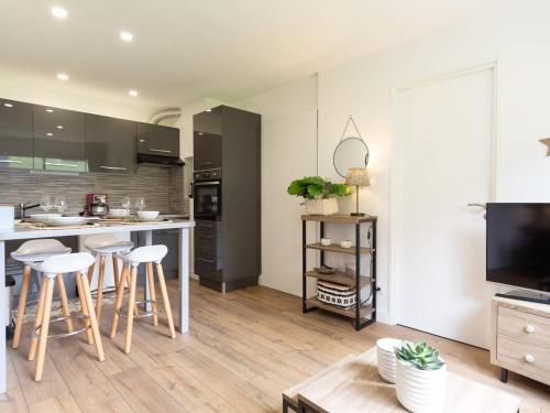 une cuisine avec un comptoir et des tabourets dans une pièce dans l'établissement Appartement rénové 3* proche des pistes avec cave, casier à ski et parking public - FR-1-296-468, à Saint-Lary-Soulan