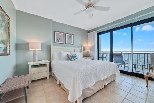a bedroom with a bed and a balcony at Grand Pointe Unit 303 in Orange Beach