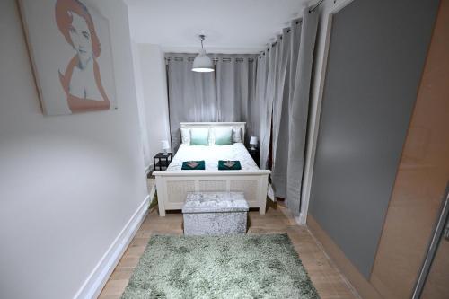 a small bedroom with a bed and a green rug at Fabulous duplex apartment in Dalston Junction in London