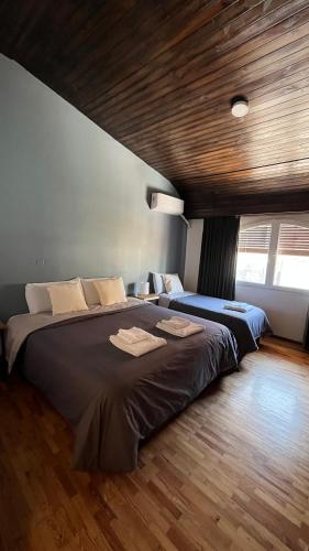 a bedroom with two beds and a wooden ceiling at Arístides Lodge in Mendoza