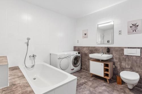 ein Badezimmer mit einer Waschmaschine und einem Waschbecken in der Unterkunft Ferienwohnung am Markt Delitzsch für 6 in Delitzsch