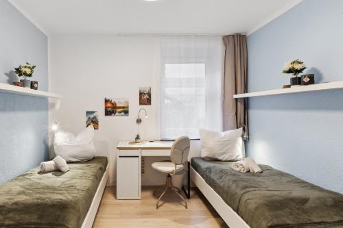 Kleines Zimmer mit 2 Betten und einem Schreibtisch. in der Unterkunft Ferienwohnung am Markt Delitzsch für 6 in Delitzsch