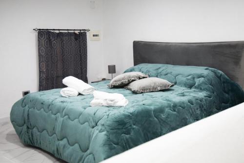 ein grünes Bett mit zwei Handtüchern darüber in der Unterkunft Palazzo Toto in Neapel