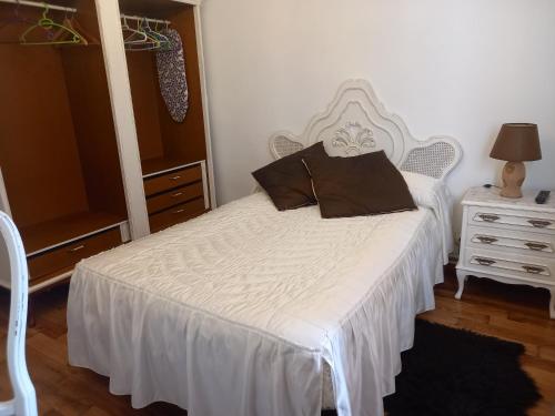 a bedroom with a white bed and a dresser at La Casuca de Ana&Isabel in Palencia