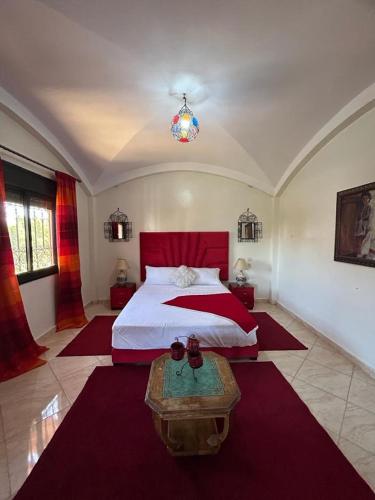 a bedroom with a large bed and a table in it at Paradise house in Marrakech