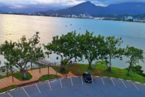 un coche aparcado en un estacionamiento junto al agua en Casa próximo a praia com churrasqueira e ar condicionado! en Caraguatatuba