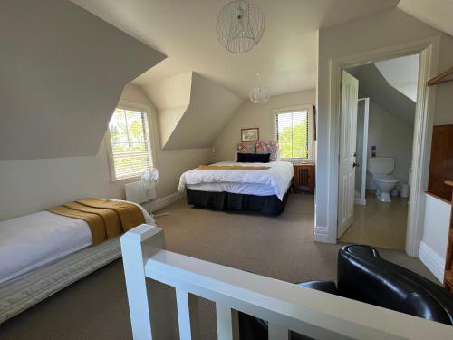 a attic bedroom with two beds and a bathroom at Pinot Villas in Martinborough 