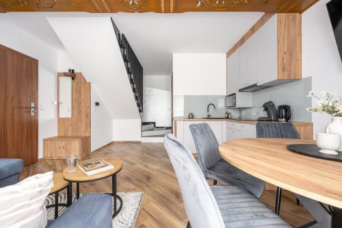 ビャウィ・ドゥナイェツにあるPara Apartmentsのキッチン、ダイニングルーム(木製のテーブルと椅子付)