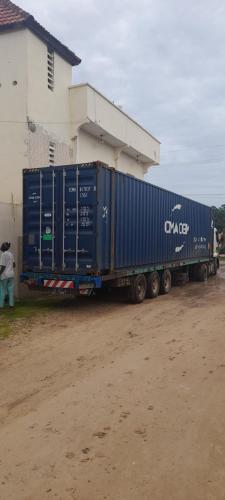 un grand camion bleu garé devant un bâtiment dans l'établissement CHEZ TAHIROU Birfy, à Fatick