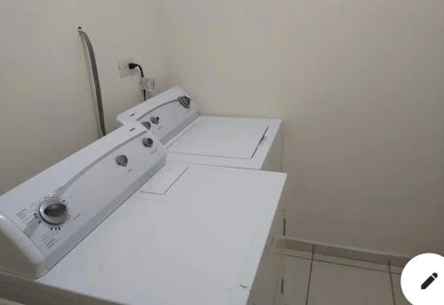 uma máquina de lavar roupa branca sentada numa casa de banho em Casa con alberca compartida Netflix Disney + Amazon TV em Hermosillo