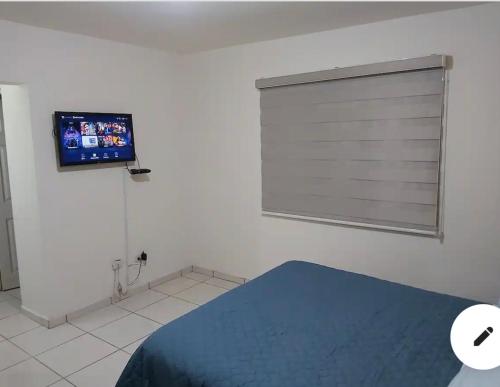 1 dormitorio con ventana y TV en la pared en Casa con alberca compartida Netflix Disney + Amazon TV, en Hermosillo