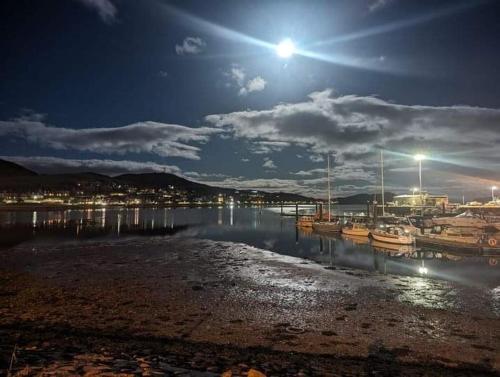 a marina at night with boats in the water at Ocean View in Campbeltown