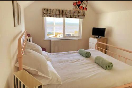 1 dormitorio con 1 cama con 2 almohadas en Stunning little house, 2 mins from Lyme Regis beach with a sea view to die for. Sleeps 2, free parking, small dog welcome., en Lyme Regis