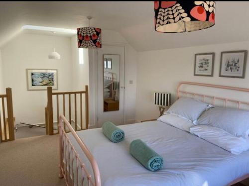 Un dormitorio con una cama con almohadas azules. en Stunning little house, 2 mins from Lyme Regis beach with a sea view to die for. Sleeps 2, free parking, small dog welcome., en Lyme Regis