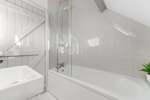 a white bathroom with a shower and a sink at Beautiful 2 Bedroom Cottage in Oxton in Oxton