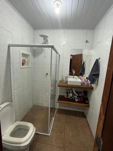 uma casa de banho com um chuveiro, um WC e um lavatório. em Vila mágica hospedagem em Itaúnas