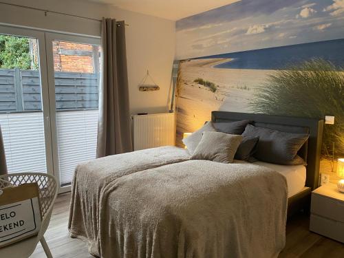 Beach II Appartement في باد سالزوفلين: غرفة نوم بسرير مع لوحة على الحائط