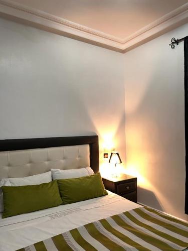 a bedroom with a bed and a nightstand with a lamp at Paradise house in Marrakech