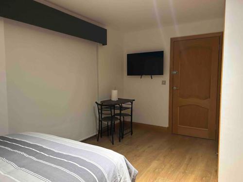 a bedroom with a bed and a table and a television at 101 Scotia Rooms in South Cobbinshaw