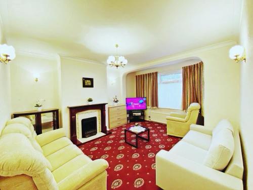 a living room with two white couches and a fireplace at Barking London House sleeps 11 - parking - train tube - airport in London