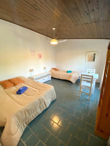 a bedroom with two beds and a table and a chair at Monoambiente Noah in Ezeiza