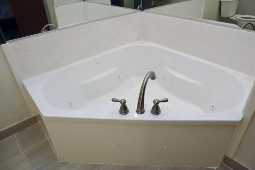 a white sink with two faucets in a bathroom at Holiday Inn Express Baton Rouge North by IHG in Zachary