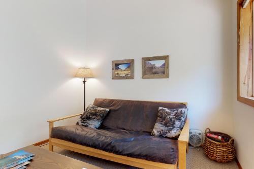 a leather couch in a living room with a lamp at The Cabins at Filoha Meadows in Redstone