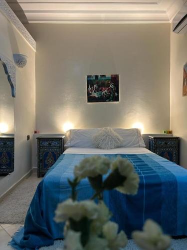 a bedroom with a bed with blue sheets and white flowers at Paradise house in Marrakech