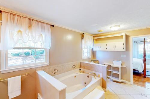 uma casa de banho com banheira e um quarto em Pondside Lullaby em Griffin