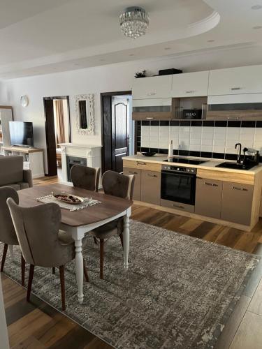 cocina con mesa y sillas en una habitación en SKY LUX apartman, en Surčin