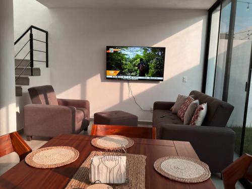 sala de estar con mesa y TV en Casa a 10 Minutos de la Playa en Nuevo Vallarta Para Máximo 8 Personas, en Mezcales