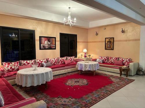 a large living room with red couches and tables at Paradise house in Marrakech