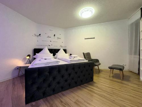 a room with a bed and two chairs in it at Modern Apartments Neuburg C - TOP - 3 Zimmer, Stellplatz, Zentrum, Wi-Fi, 3 TV, Küche in Neuburg an der Donau