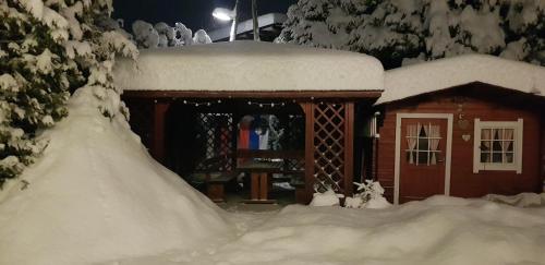 a snow covered cabin with a pile of snow at Zajček Apartma in Mojstrana