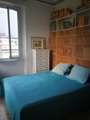 a bedroom with a bed with blue sheets and a window at Blue Room Shared House Terrace above in Genoa