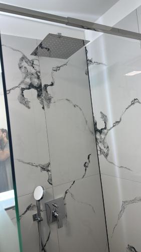 eine gläserne Duschkabine mit schwarzem und weißem Marmor in der Unterkunft Residence Unique in Râșnov