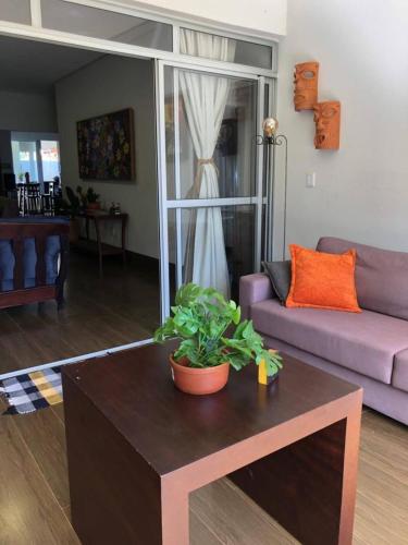 a living room with a table and a purple couch at Casa bela e confortável em Chapada dos Guimarães in Chapada dos Guimarães