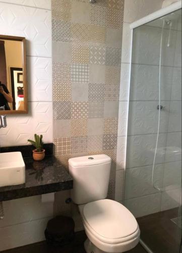 a bathroom with a toilet and a sink and a shower at Casa bela e confortável em Chapada dos Guimarães in Chapada dos Guimarães