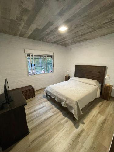 um quarto com uma cama, uma secretária e uma janela em Casa en Maldonado em Maldonado