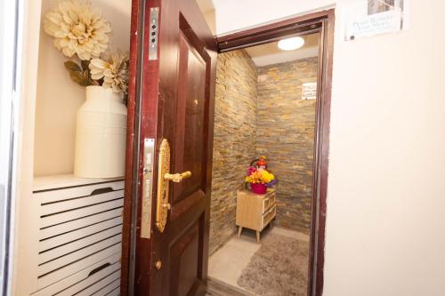 a door leading into a hallway with a stone wall at Airstaybnb in Manchester